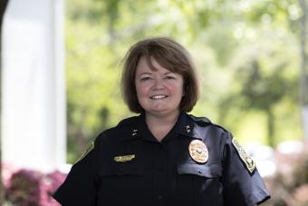 Deputy Chief Fielding in uniform stands smiling near a UVA pillar